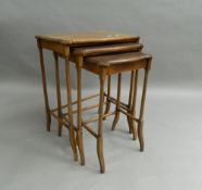 A nest of three early 20th century mahogany tables. 53.5 cm wide.