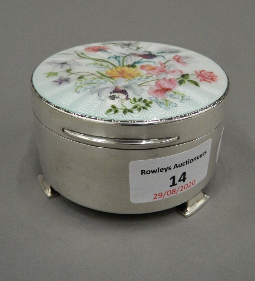 A fine hallmarked silver trinket box with hinged enamelled lid decorated with flowers.