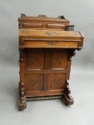 A Victorian carved walnut Davenport. 56.5 cm wide x 55 cm deep.