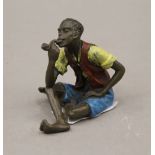 A cold painted bronze model of a boy smoking a pipe. 6 cm high.