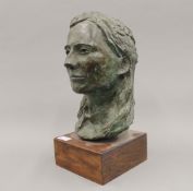 A female patinated bronze bust mounted on a wooden display plinth,