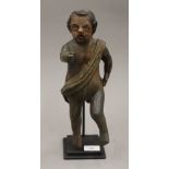 An 18th/19th century carved wooden model of an infant with sash, on metal base. 35 cm high.