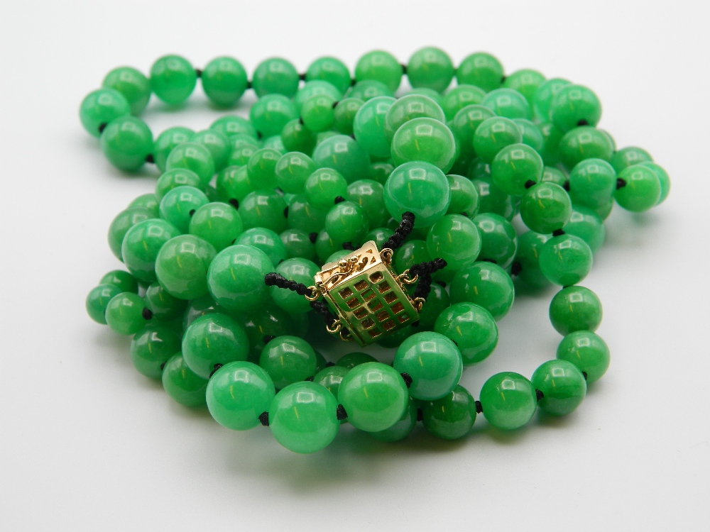 A three strand jade bead necklace with a 14 ct gold and diamond clasp. 50 cm long.