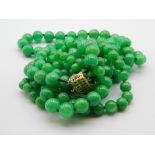 A three strand jade bead necklace with a 14 ct gold and diamond clasp. 50 cm long.