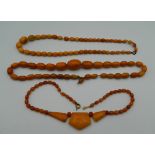 An amber bead necklace and two others. The largest 48 cm long.