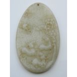 A carved oval jade pendant. 8 cm high.