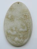 A carved oval jade pendant. 8 cm high.