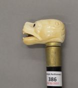 A walking stick with a carved bone handle formed as a dog. 89 cm long.