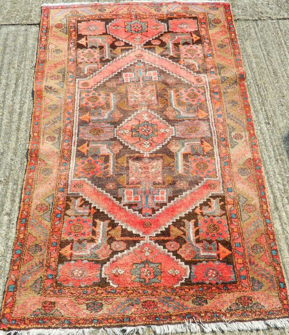 A Persian red ground wool rug. 200 x 128 cm.