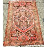 A Persian red ground wool rug. 200 x 128 cm.