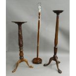 Two mahogany torcheres and a standard lamp. The lamp 171 cm high.