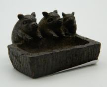 A Japanese bronze model of three piglets at a trough. 4.5 cm wide.