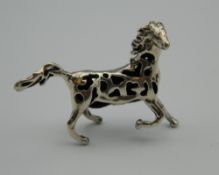 A silver pin cushion in the form of a horse. 4 cm wide.