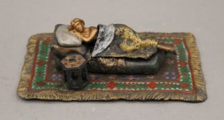 A cold painted bronze model of a sleeping girl.