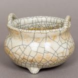 An antique Chinese crackle glaze censer Of squat circular form with twin loop handles,