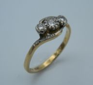 An 18 ct gold three diamond trilogy ring. Ring size R (3.