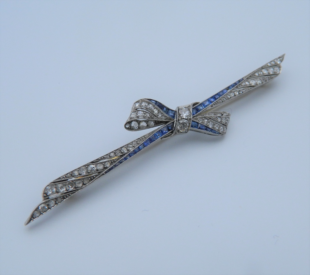 An Edwardian platinum diamond and sapphire bow brooch with an 18 ct gold pin.