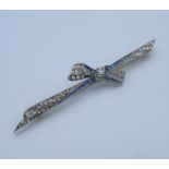 An Edwardian platinum diamond and sapphire bow brooch with an 18 ct gold pin.