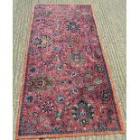 A red ground Persian wool rug. 246 x 125 cm.