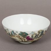A Chinese porcelain bowl Decorated with figures amongst mountainous lakeland landscape on a white