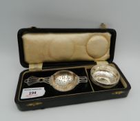 A boxed silver tea strainer and bowl (52 grammes total weight)