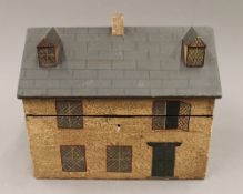 A wooden box formed as a house. 26 cm wide.