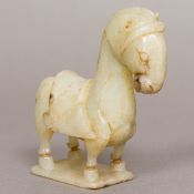 A Chinese carved pale jade model of a horse Formed standing and with a saddle. 9 cm high.