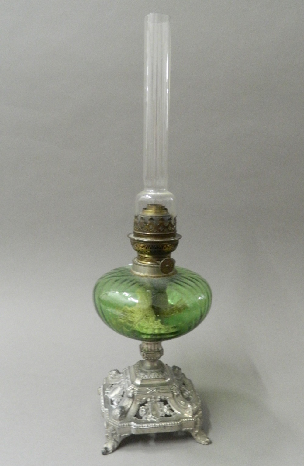 A Victorian oil lamp with green glass reservoir. 52 cm high.