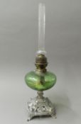 A Victorian oil lamp with green glass reservoir. 52 cm high.