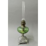 A Victorian oil lamp with green glass reservoir. 52 cm high.