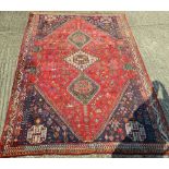 A red ground Persian wool rug. 259 x 185 cm.