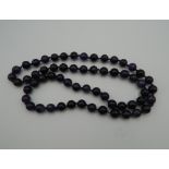 A string of amethyst beads. 69 cm long.