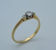 An 18 ct gold three diamond trilogy ring. Ring size T (2.