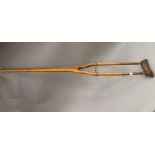 A 19th century brass and wooden crutch. 131 cm long.