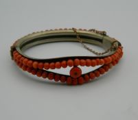 A Victorian coral mounted bangle form bracelet. 7 cm wide.