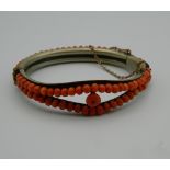 A Victorian coral mounted bangle form bracelet. 7 cm wide.