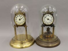 Two brass Anniversary clocks, under glass domes. The largest 30 cm high.