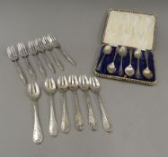 A case set of silver teaspoons each decorated with golf clubs (79.