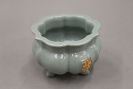 A Chinese celadon glaze censer with calligraphic panel. 12 cm wide.