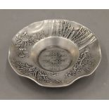 A Chinese white metal dish. 11 cm diameter.