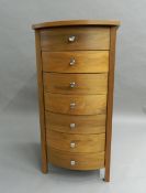 A modern slender bowfront chest of drawers.