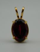 An 18 ct gold and garnet pendant. 2.5 cm high (6.