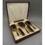 A cased silver and tortoiseshell dressing set (lacking comb). The case 34 cm wide.
