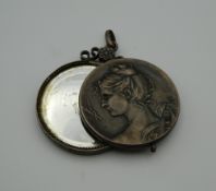 A 19th century Continental white metal pendant enclosing a mirror. 4.5 cm wide.