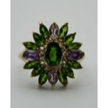 A 9 ct gold green garnet, amethyst and diamond flowerhead ring. Ring Size Q.