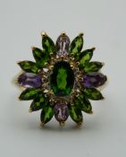 A 9 ct gold green garnet, amethyst and diamond flowerhead ring. Ring Size Q.