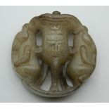 A Chinese carved jade roundel. 5 cm high.