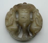 A Chinese carved jade roundel. 5 cm high.