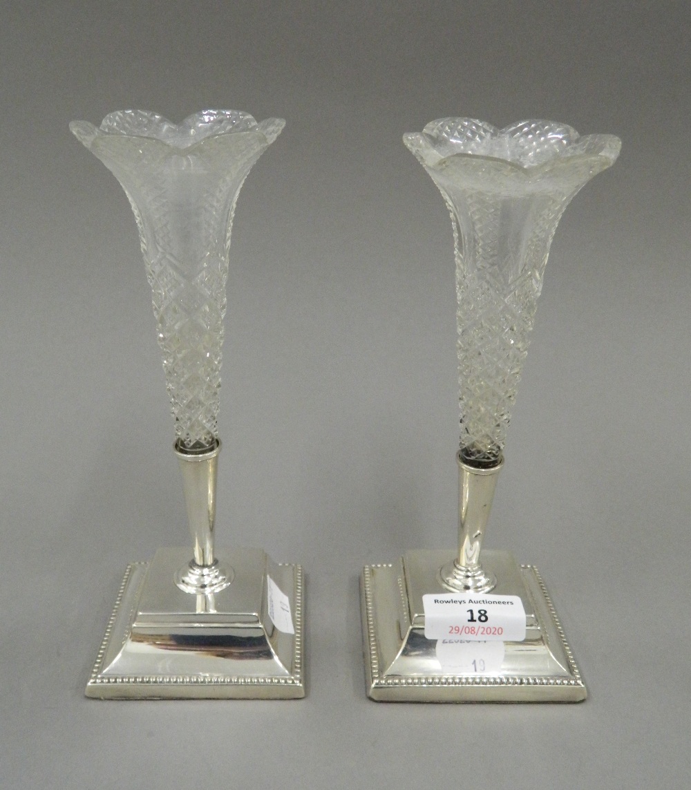 A pair of silver and glass bud vases. Each 20 cm high.