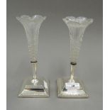 A pair of silver and glass bud vases. Each 20 cm high.